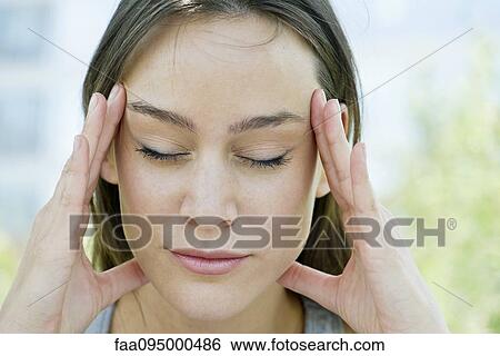 Stock Photograph - Woman rubbing temples. Fotosearch