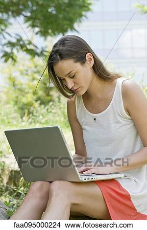 Picture - Woman using laptop computer outdoors. Fotosearch