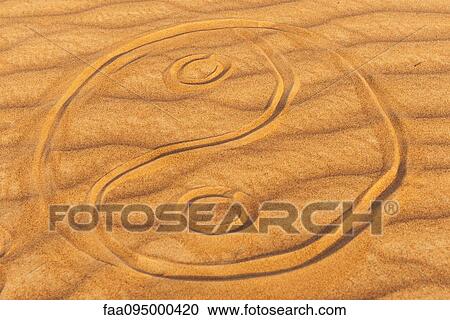 Stock Image - Yin yang symbol drawn in sand. Fotosearch
