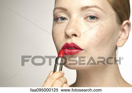 Young woman applying lipstick, portrait View Large Photo Image Stock Photography - Young woman applying lipstick, portrait. Fotosearch