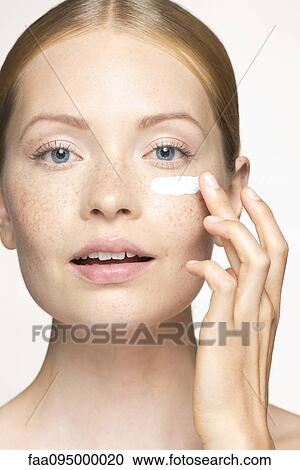 Young woman applying moisturizer under eye View Large Photo Image Stock Image - Young woman applying moisturizer under eye. Fotosearch