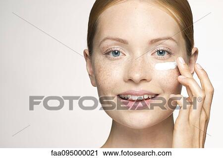 Young woman applying moisturizer under eye View Large Photo Image Stock Image - Young woman applying moisturizer under eye. Fotosearch