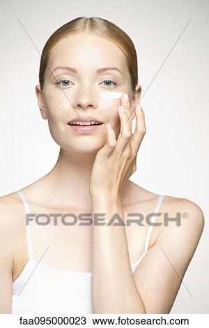 Young woman applying moisturizer under eye View Large Photo Image Stock Image - Young woman applying moisturizer under eye. Fotosearch