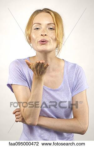 Young woman blowing a kiss, portrait View Large Photo Image Stock Image - Young woman blowing a kiss, portrait. Fotosearch