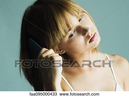 Young woman brushing hair View Large Photo Image Stock Image - Young woman brushing hair. Fotosearch