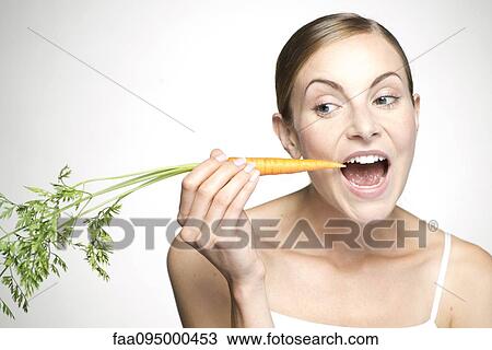 Young woman eating carrot View Large Photo Image Stock Image - Young woman eating carrot. Fotosearch