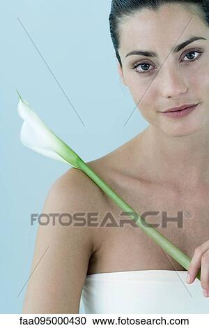 Young woman holding calla lily, portrait View Large Photo Image Stock Image - Young woman holding calla lily, portrait. Fotosearch
