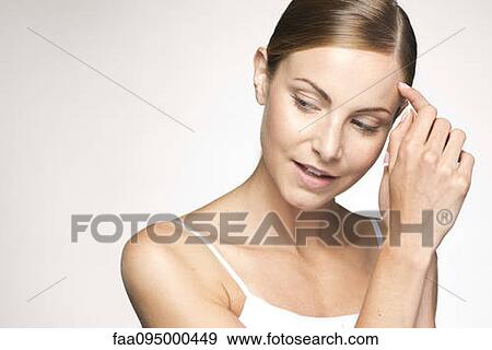 Young woman holding clasped hands against face, portrait View Large Photo Image Stock Photo - Young woman holding clasped hands against face, portrait. Fotosearch