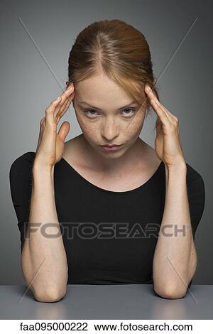 Young woman holding head, portrait View Large Photo Image Stock Image - Young woman holding head, portrait. Fotosearch