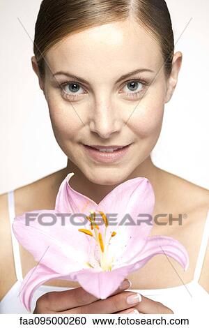 Young woman holding lily, portrait View Large Photo Image Stock Image - Young woman holding lily, portrait. Fotosearch