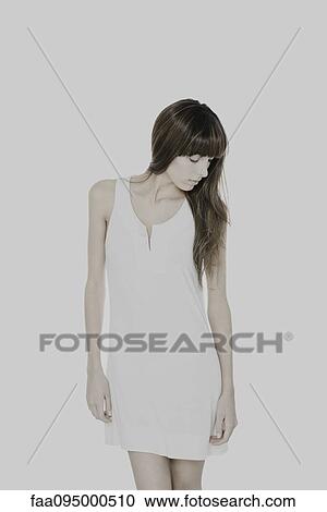 Young woman in dress, head down, eyes closed View Large Photo Image Stock Image - Young woman in dress, head down, eyes closed. Fotosearch