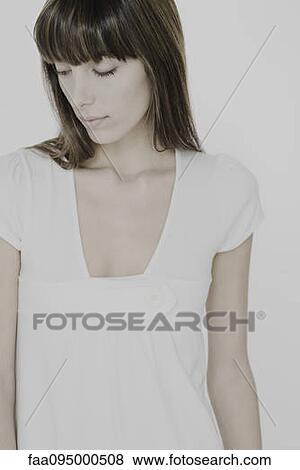 Stock Photo - Young woman looking down, portrait. Fotosearch