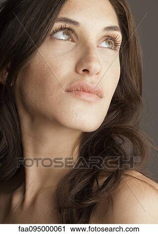 Stock Image - Young woman, looking up, portrait. Fotosearch