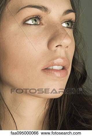 Stock Photograph - Young woman, looking up, portrait. Fotosearch