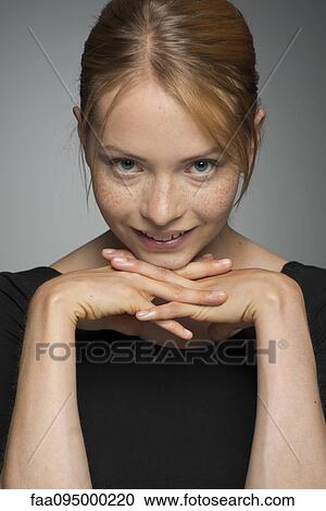 Young woman resting chin on hands, smiling, portrait View Large Photo Image Stock Image - Young woman resting chin on hands, smiling, portrait. Fotosearch
