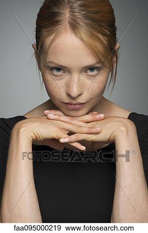 Young woman resting chin on hands, looking seductively at camera View Large Photo Image Stock Photo - Young woman resting chin on hands, looking seductively at camera. Fotosearch