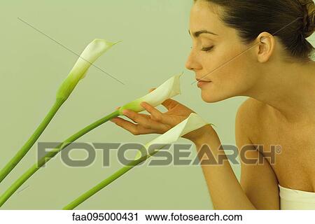 Young woman smelling calla lilies View Large Photo Image Stock Image - Young woman smelling calla lilies. Fotosearch