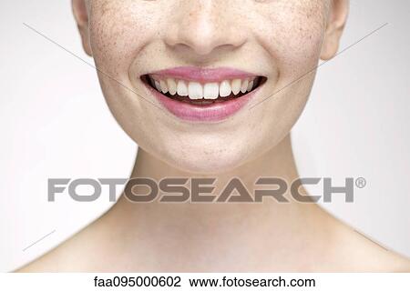Stock Image - Young woman smiling, cropped portrait. Fotosearch