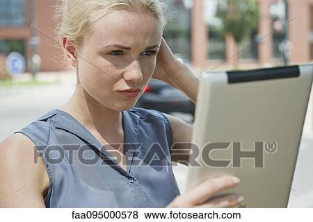 Young woman using digital tablet to take a photograph View Large Photo Image Stock Photo - Young woman using digital tablet to take a photograph. Fotosearch
