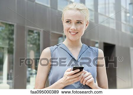 Young woman using smartphone View Large Photo Image Stock Photo - Young woman using smartphone. Fotosearch