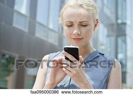 Young woman using smartphone View Large Photo Image Stock Photograph - Young woman using smartphone. Fotosearch