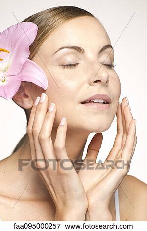 Young woman wearing lily in hair, eyes closed, portrait View Large Photo Image Stock Photo - Young woman wearing lily in hair, eyes closed, portrait. Fotosearch