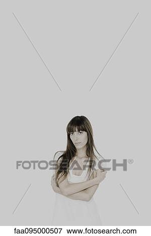 Young woman with arms folded, looking at camera View Large Photo Image Stock Photo - Young woman with arms folded, looking at camera. Fotosearch