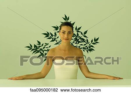 Young woman with bare shoulders standing at counter, leaf pattern in background View Large Photo Image Stock Image - Young woman with bare shoulders standing at counter, leaf pattern in background. Fotosearch