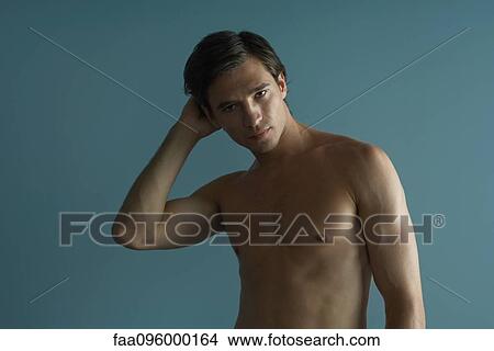 Picture - Barechested man with hand on head looking at camera. Fotosearch