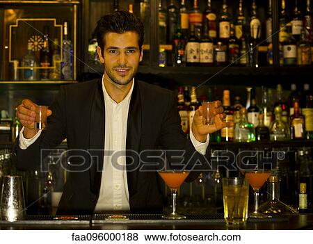Stock Photo - Bartender serving shots. Fotosearch