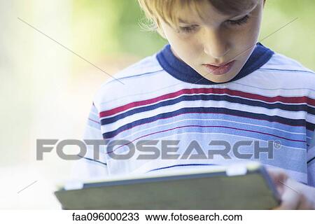 Boy using digital tablet View Large Photo Image Stock Image - Boy using digital tablet. Fotosearch