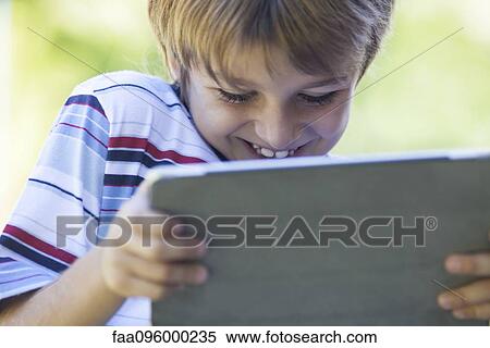 Stock Photography - Boy using digital tablet. Fotosearch