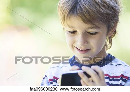 Stock Image - Boy using smartphone. Fotosearch