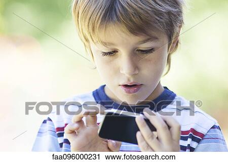 Stock Image - Boy using smartphone. Fotosearch