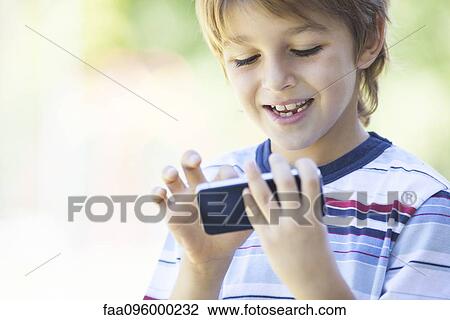 Stock Image - Boy using smartphone. Fotosearch