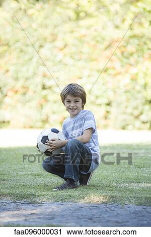 Stock Image - Boy with soccer ball, portrait. Fotosearch
