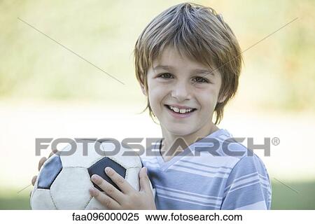 Stock Photography - Boy with soccer ball, portrait. Fotosearch
