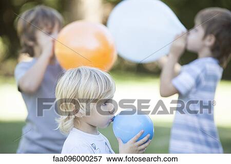 Boys blowing balloons View Large Photo Image Stock Photo - Boys blowing balloons. Fotosearch