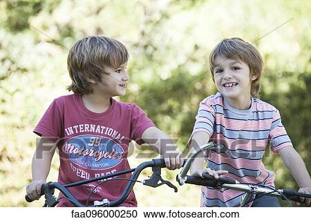 Boys riding bicycles side by side View Large Photo Image Stock Image - Boys riding bicycles side by side. Fotosearch