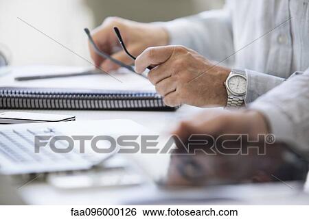 Businessman working at desk, cropped View Large Photo Image Stock Photograph - Businessman working at desk, cropped. Fotosearch