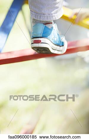 Stock Photography - Child climbing on jungle gym, low section. Fotosearch