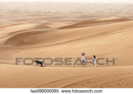 Stock Photography - Children walking on dune in desert. Fotosearch