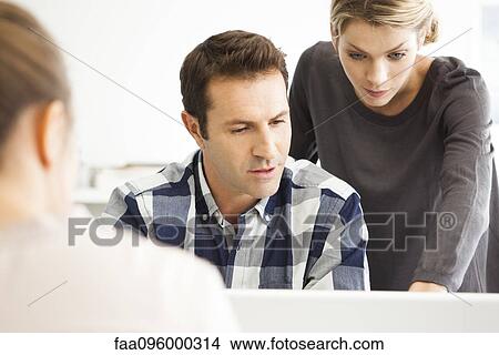Picture - Colleagues working as team on work project. Fotosearch