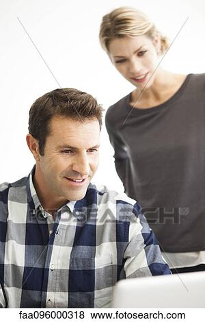 Stock Photo - Colleagues working together on work project. Fotosearch