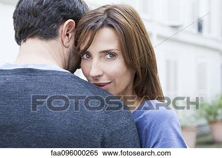 Couple embracing, woman looking at camera View Large Photo Image Stock Photography - Couple embracing, woman looking at camera. Fotosearch