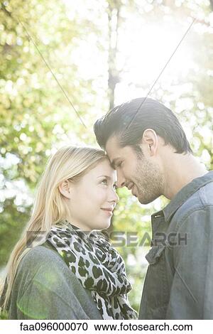Couple nuzzling each other outdoors View Large Photo Image Stock Image - Couple nuzzling each other outdoors. Fotosearch