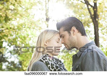 Couple nuzzling with eyes closed outdoors View Large Photo Image Stock Photo - Couple nuzzling with eyes closed outdoors. Fotosearch