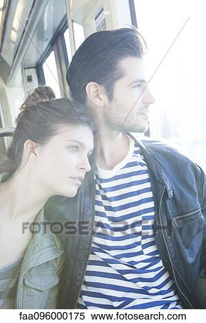 Stock Photography - Couple riding train together, looking out window. Fotosearch