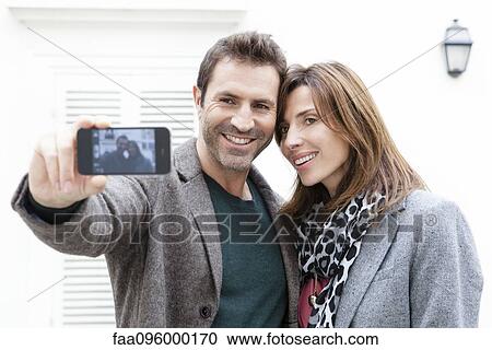 Couple taking self portrait with camera phone View Large Photo Image Stock Image - Couple taking self portrait with camera phone. Fotosearch