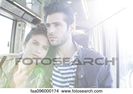 Picture - Couple together on train, woman resting her head on man's shoulder. Fotosearch